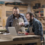 2 men using laptop